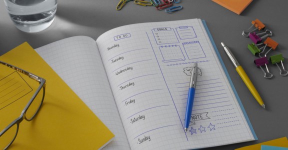 Notebook planner with Parker pen on a desk