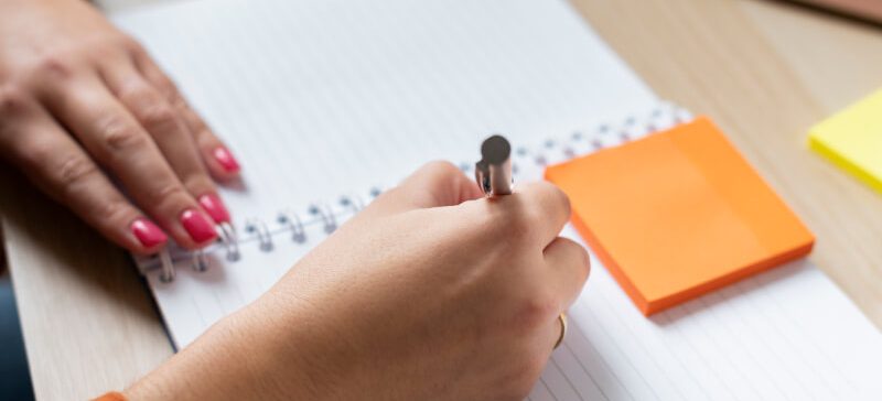 Person writing on notebook